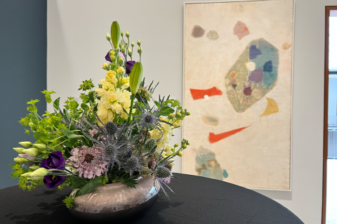 floral display with artwork behind it